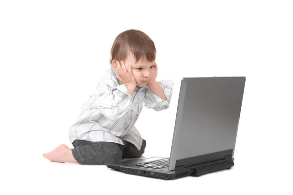 Bambino tenendo la testa con il computer portatile — Foto Stock