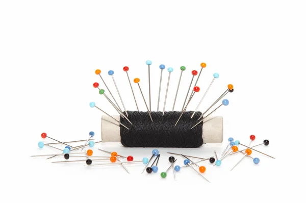 Scattered needles around reel of thread — Stock Photo, Image