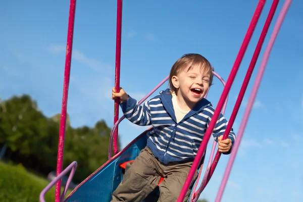 Laughing baby on the swing — Stock Photo, Image