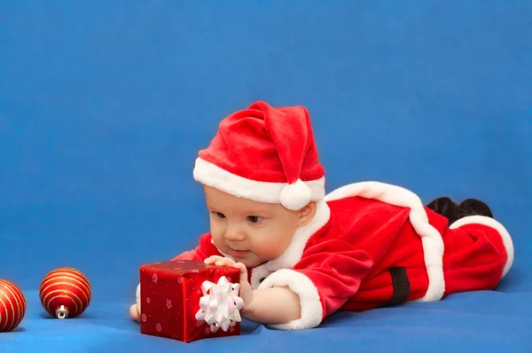 Baby i tomtens kostym med gåva — Stockfoto