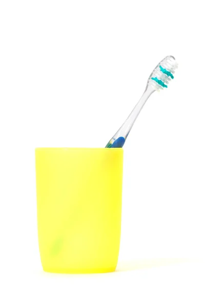 Зубная щетка в желтой чашке — стоковое фото