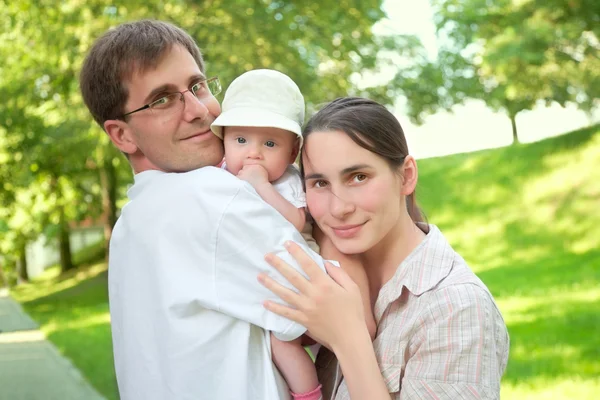 Smiling young family with a baby — Stock Photo, Image