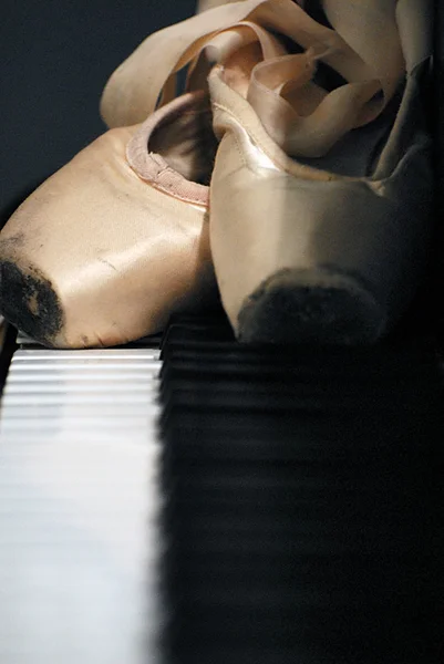 Sapatos Pointe deitado em um piano Fotos De Bancos De Imagens
