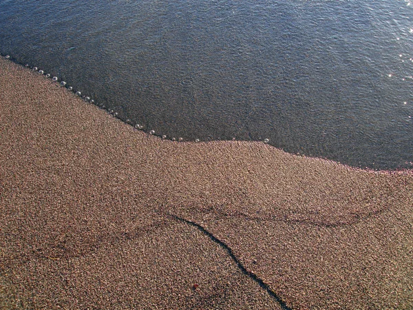 Вода мягко встречает песчаный берег — стоковое фото