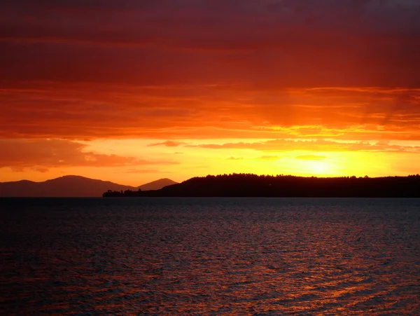 Pôr-do-sol vermelho profundo sobre o Lago Taupo, NZ — Fotografia de Stock