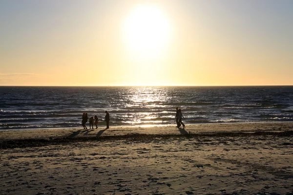 Spacery wzdłuż plaży o zachodzie słońca — Zdjęcie stockowe