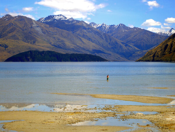 Man wading in Lake Wanaka, New Zealand