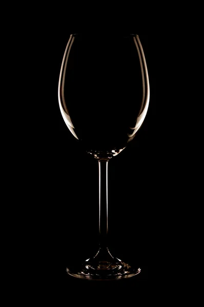 Leeg glas wijn aan de achterkant licht. — Stockfoto