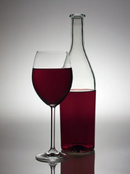 Glas och flaska med rött vin — Stockfoto
