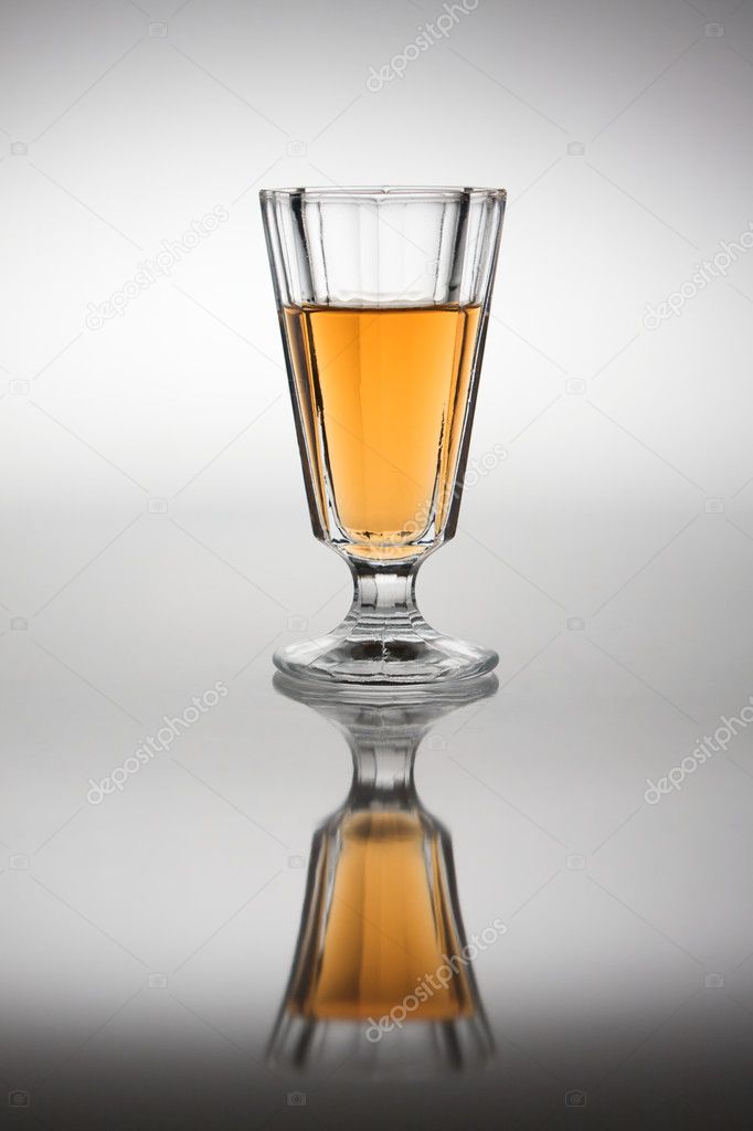 Glass with plum wine in back light.