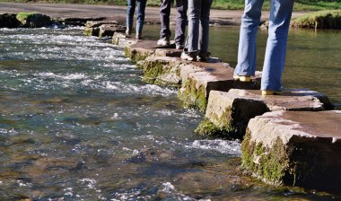 Crossing river on stepping stones clipart