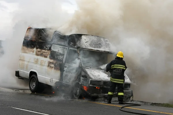 Bombero y vehículo en llamas — Foto de Stock