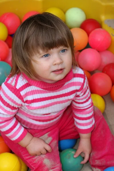 Menina pequena e bolas — Fotografia de Stock