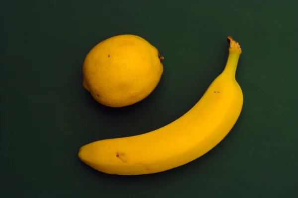 Citron et banane sur fond vert — Photo