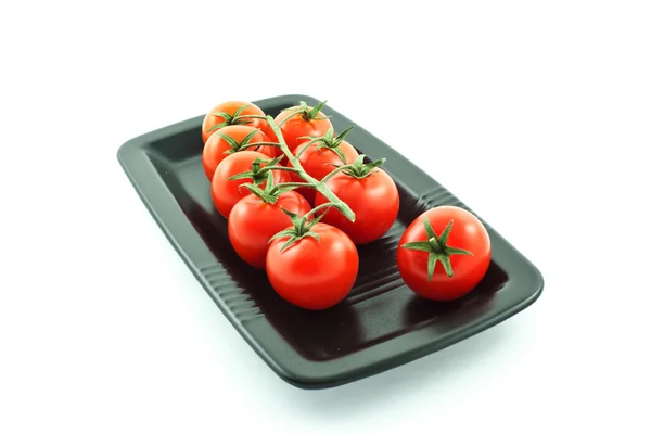 Tomat banyak di piring hitam — Stok Foto