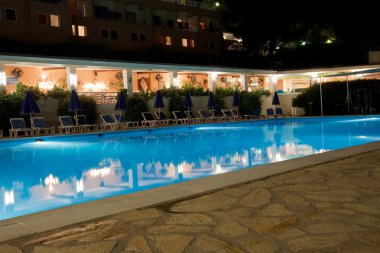 Pool of Greek hotel at night clipart