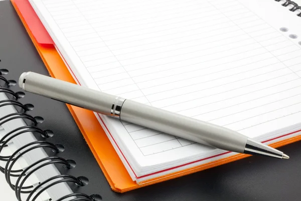 Två bärbara datorer papper och penna — Stockfoto