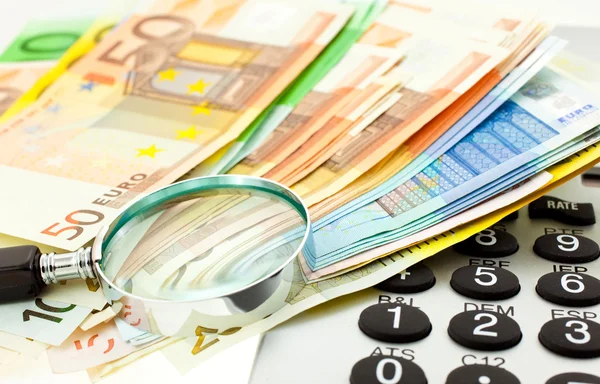 Euro with calculator and magnifier — Stock Photo, Image
