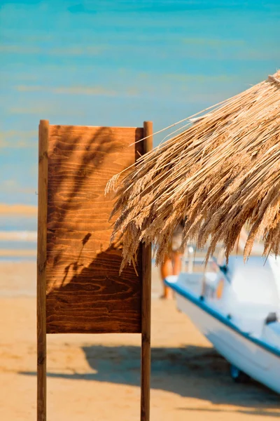 En strandparaply laget av siv – stockfoto