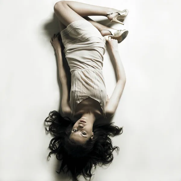 Femme séduisante pose sur drap de lit blanc — Photo