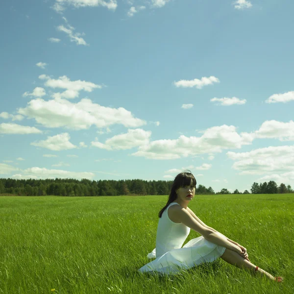 Beautiful young woman on a green field — Stock Photo, Image