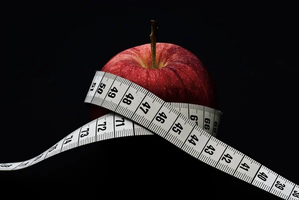 Red apple with measuring tape — Stock Photo, Image