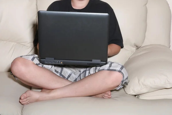 Мальчик серфингирует в Интернете на ноутбуке — стоковое фото