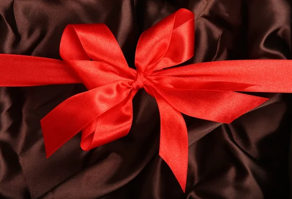 Red ribbon brown textile backgrou — Stock Photo, Image