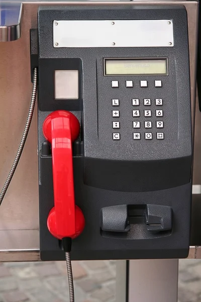 Black public phone with red receiver — Stock Photo, Image