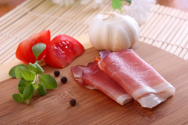 Prosciutto with tomatoes and garlic — Stock Photo, Image