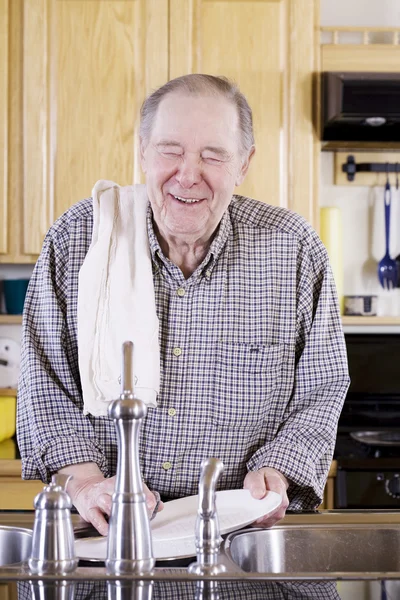 Пожилой человек моет посуду — стоковое фото