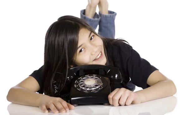 Young girl lying by old phone — Stock Photo, Image