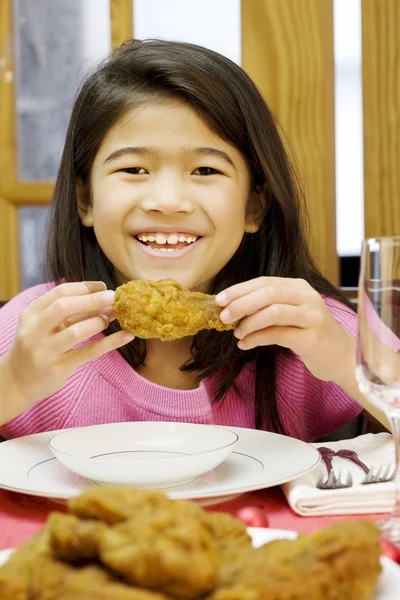 Girl eating fried chicken drumstick — Stock Photo, Image