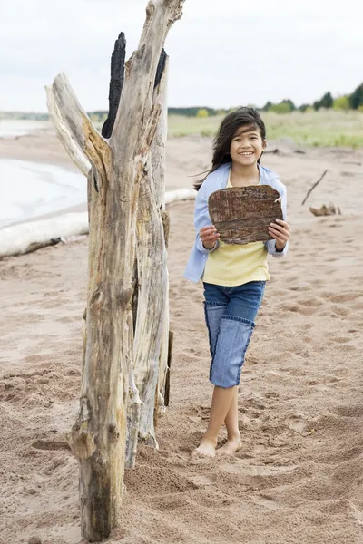 Маленькая девочка на пляже с табличкой — стоковое фото