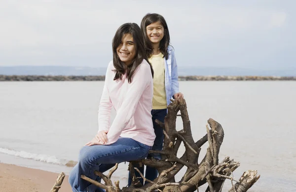Two sisters sitting by lake — Stock Photo, Image