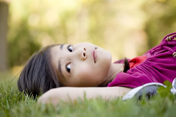 Holčička ležící na trávě — Stock fotografie