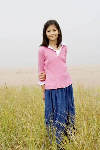 Chica de pie en el campo de hierba alta — Foto de Stock