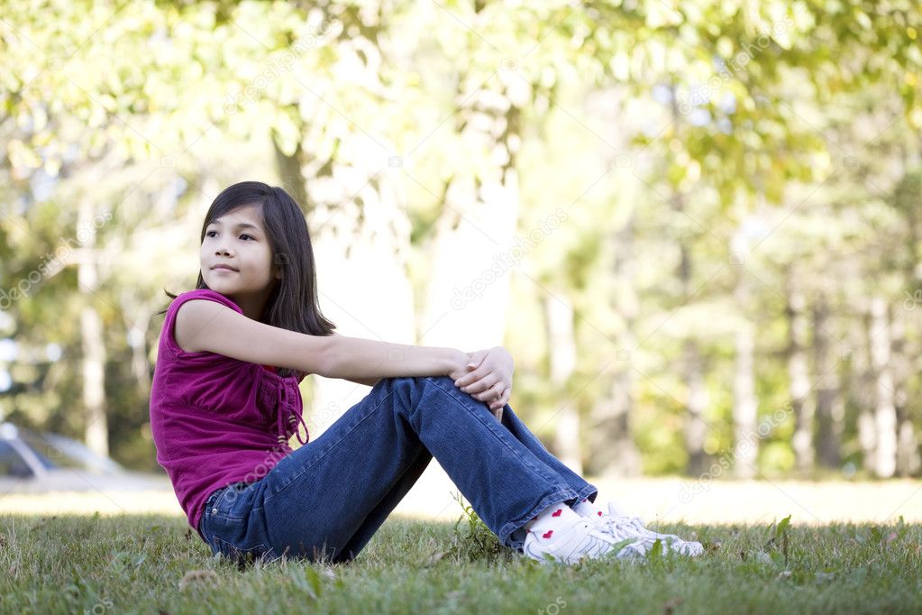 Little girl sitting on grass