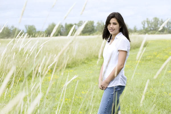 Vacker teen flicka i gräsbevuxna fält — Stockfoto