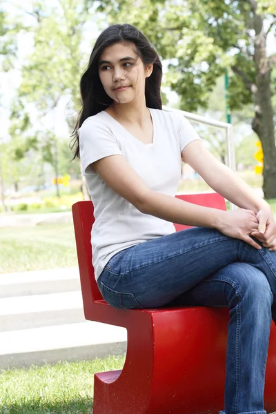 Krásná dospívající dívka sedí venku — Stock fotografie