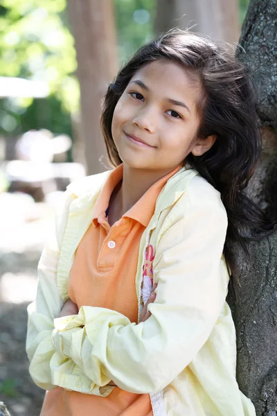 Νεαρό κορίτσι χαλαρωτικό κατά δέντρο — Φωτογραφία Αρχείου