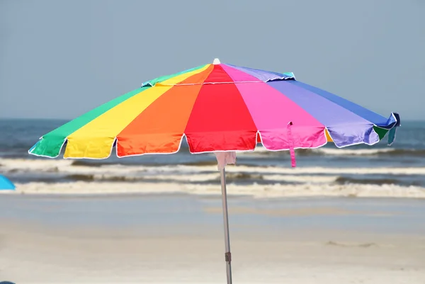 Colorful umbrella by beach — Stock Photo, Image