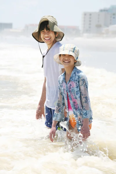 Los niños se arrodillan en olas oceánicas —  Fotos de Stock