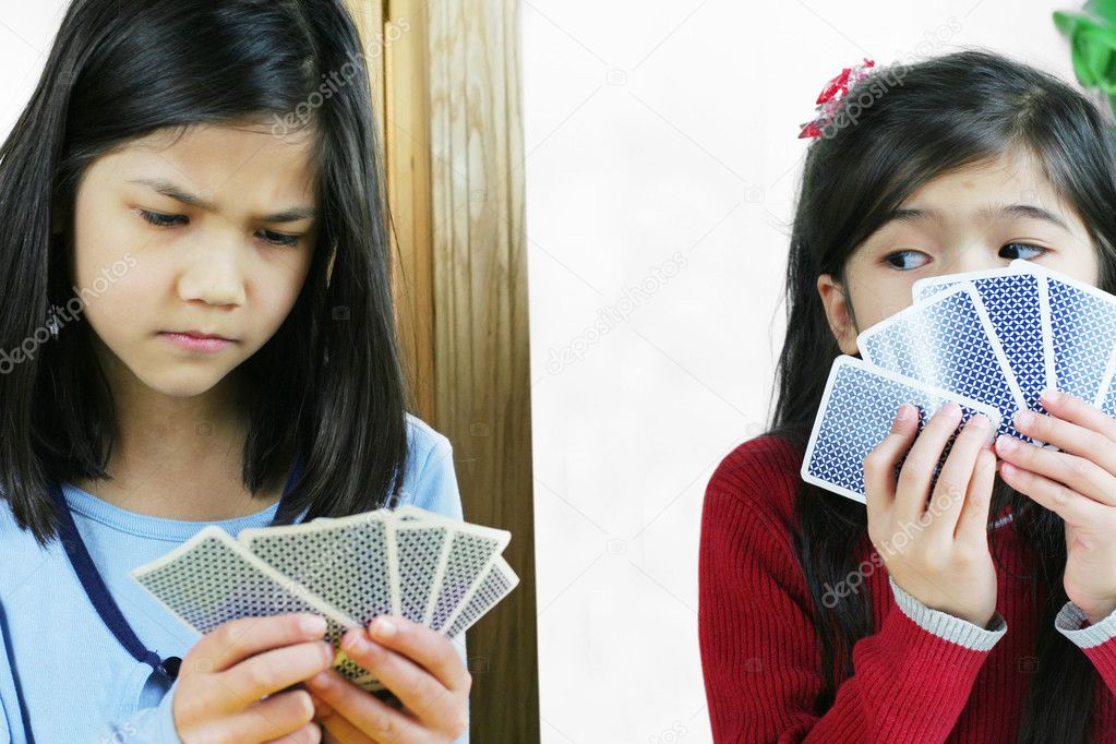 Girls playing cards, one is cheating