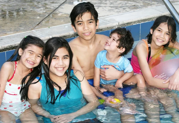 Cinco niños sentados en la piscina —  Fotos de Stock