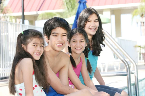 Cuatro niños junto a la piscina —  Fotos de Stock