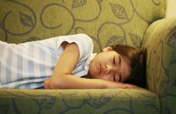Kleines Mädchen schläft auf Couch — Stockfoto