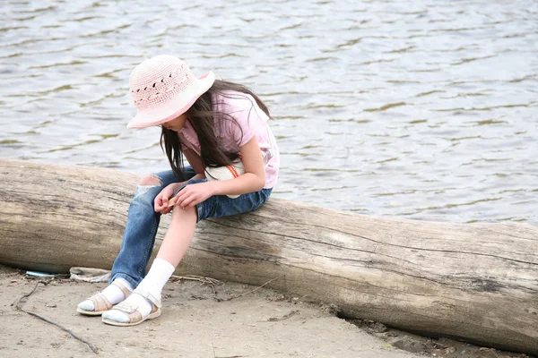 Meisje met wond zittend op logboek — Stockfoto