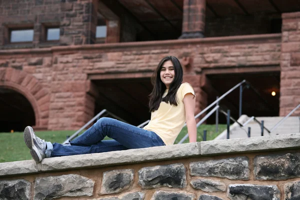 十几岁的女孩坐在岩石壁架上 — 图库照片