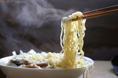 Chopsticks holding oriental noodles